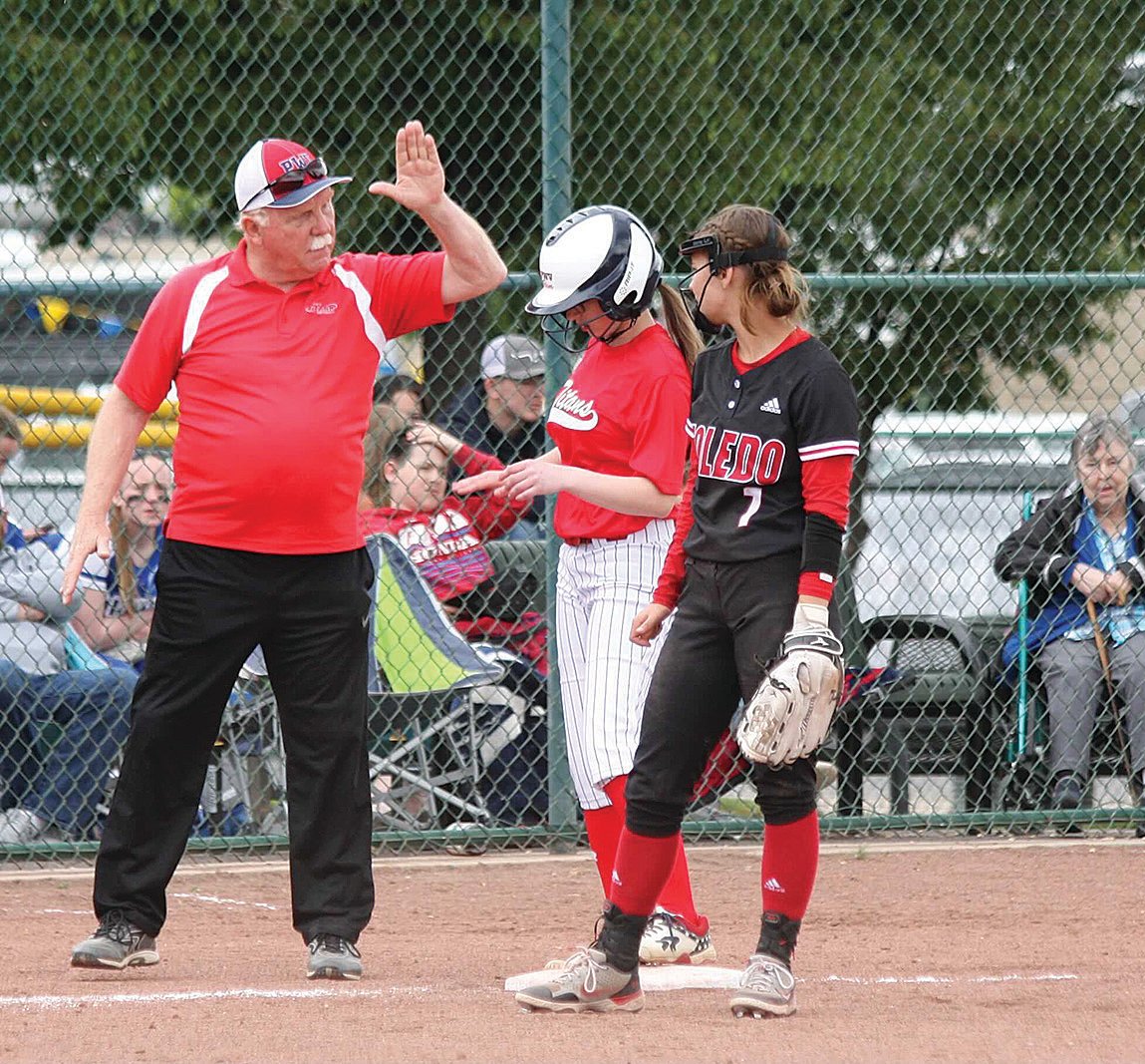PWV coach Ken Olson congratulates a player on Friday during a win over Toledo in the 2B state softball tournament in Yakima.